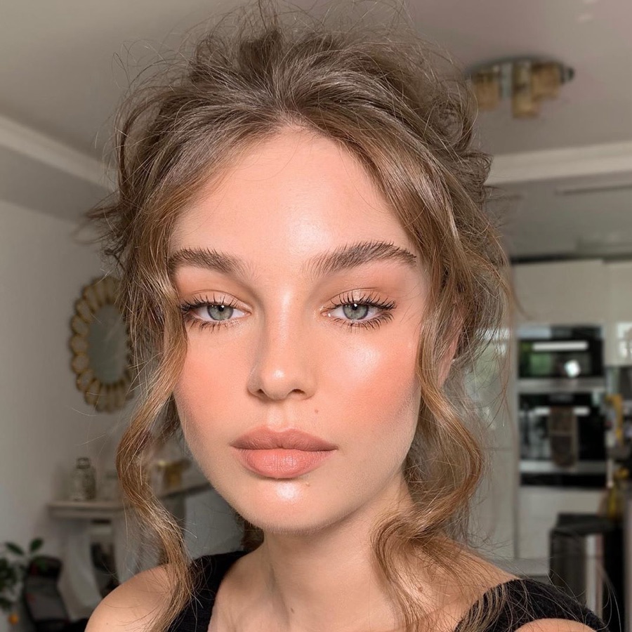Teint pêche lumineux et chignon flou